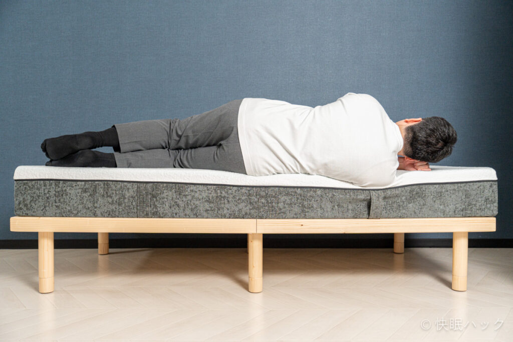 快眠タイムズマットレス3.0の端で横向き寝をしている筆者を真横から撮影。